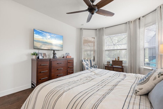 bedroom featuring ceiling fan, dark hardwood / wood-style flooring, and multiple windows