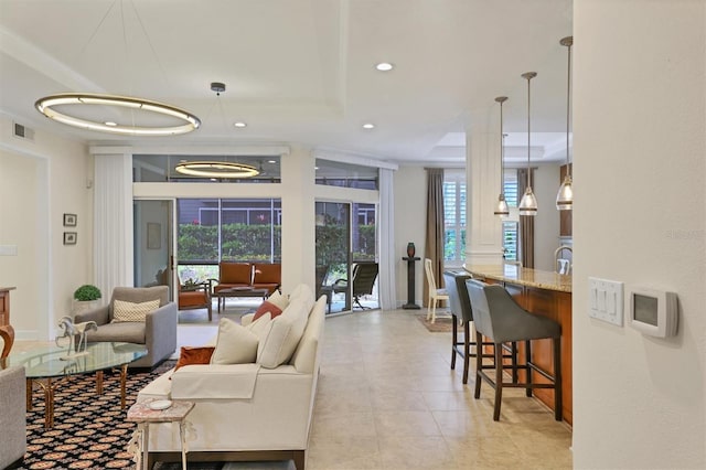 living room with ornamental molding, plenty of natural light, and light tile patterned floors