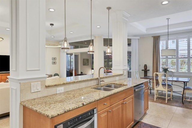 kitchen featuring light stone counters, light tile patterned floors, sink, stainless steel dishwasher, and decorative light fixtures