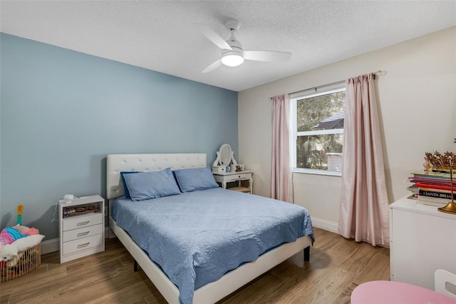 bedroom featuring wood-type flooring, a textured ceiling, and ceiling fan