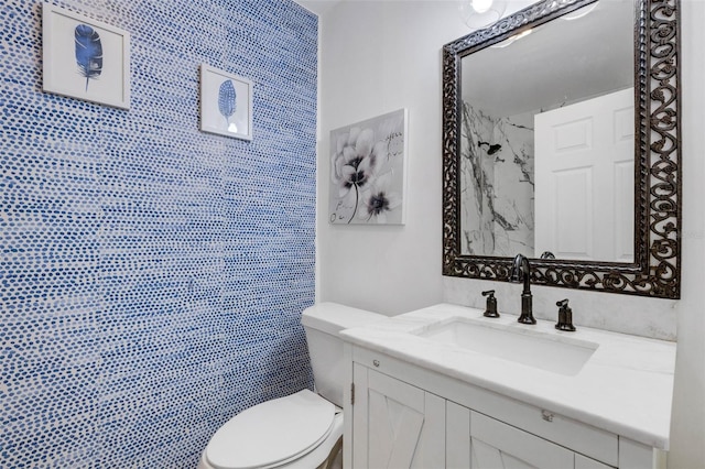 bathroom with vanity, toilet, and a tile shower