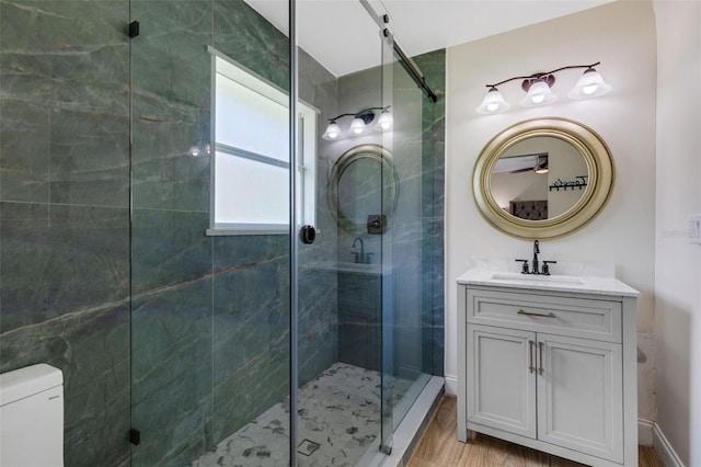 bathroom with vanity, a shower with shower door, toilet, and hardwood / wood-style flooring