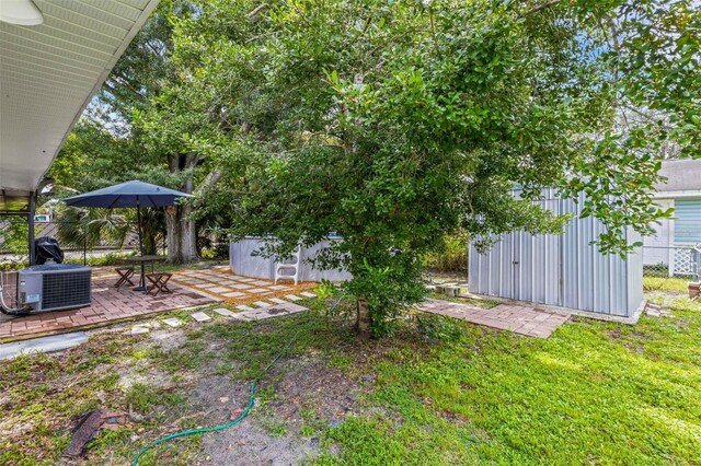 view of yard with a patio, a storage shed, and central AC