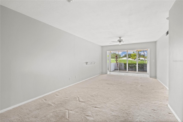 unfurnished room featuring ceiling fan, carpet, and a textured ceiling