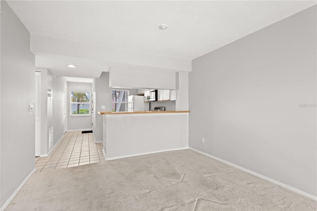 unfurnished living room with light colored carpet