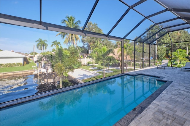 view of swimming pool with glass enclosure and a patio