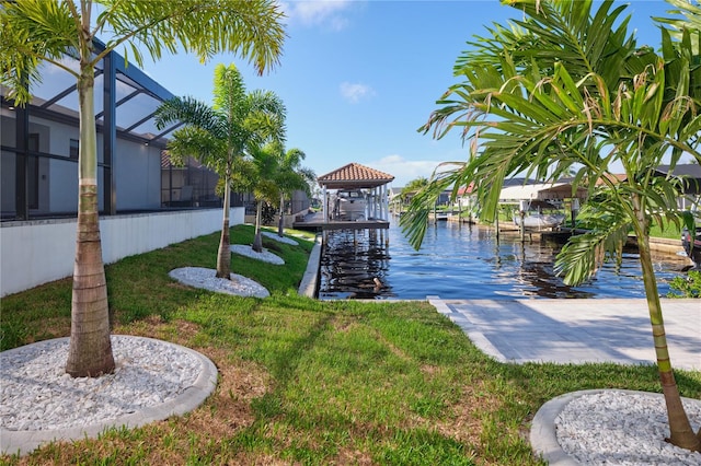 view of dock featuring a lanai, a lawn, and a water view