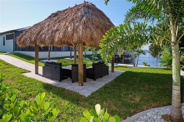 exterior space featuring a water view, outdoor lounge area, a patio, and a gazebo