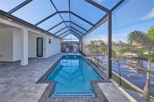 view of swimming pool featuring glass enclosure and a patio area