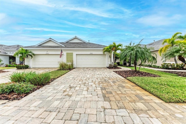 ranch-style home with a garage, decorative driveway, and stucco siding