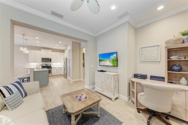 living area with ornamental molding, light wood-type flooring, and visible vents