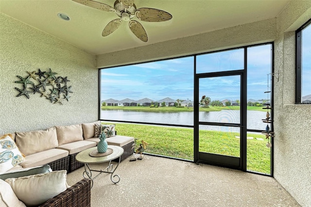 sunroom featuring a water view and a ceiling fan