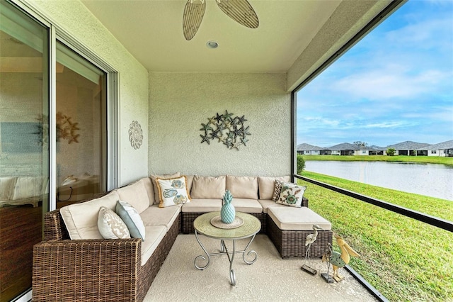 sunroom with a water view and a ceiling fan