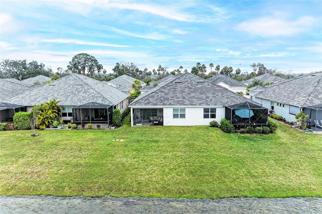 back of house with a lanai, a yard, and stucco siding