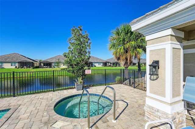 view of pool with a hot tub, a residential view, a water view, fence, and a patio area