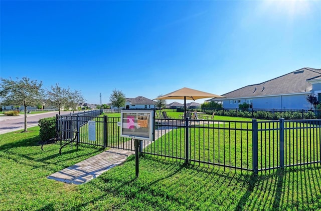 view of community with a yard, a residential view, fence, and a gate