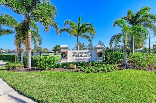 community sign with fence and a yard