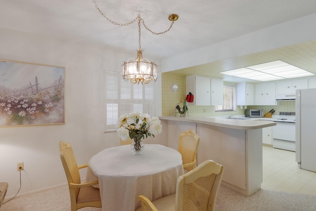 dining space with an inviting chandelier and sink