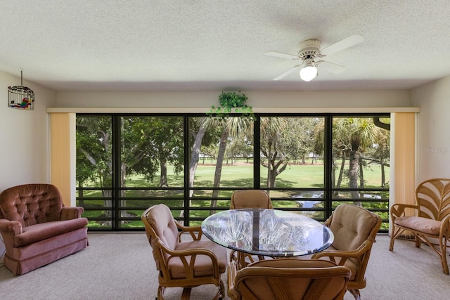 dining area with a textured ceiling, plenty of natural light, ceiling fan, and carpet floors