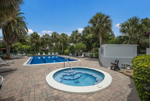 view of pool featuring a community hot tub and a patio area