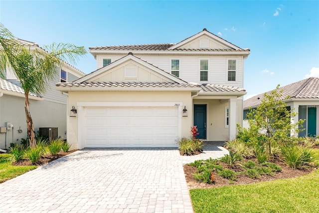 view of front of property featuring a garage and central air condition unit