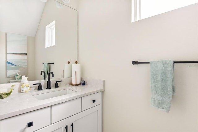 bathroom featuring lofted ceiling and vanity