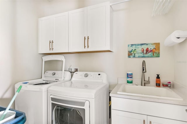 washroom featuring cabinets, sink, and independent washer and dryer