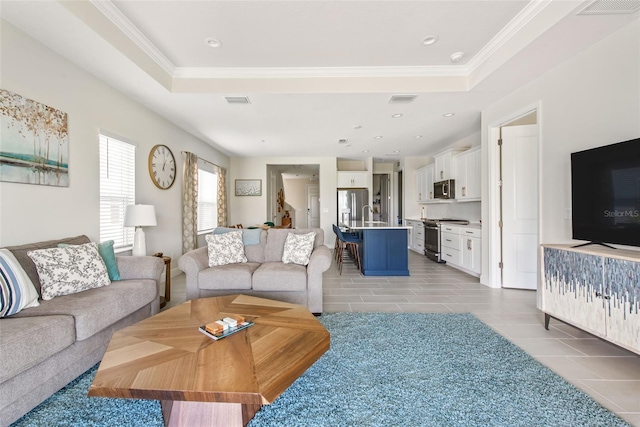 tiled living room featuring crown molding and a raised ceiling