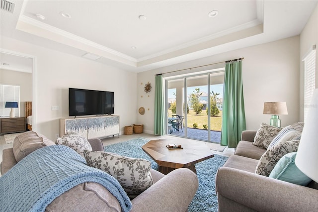 living room featuring a tray ceiling and crown molding