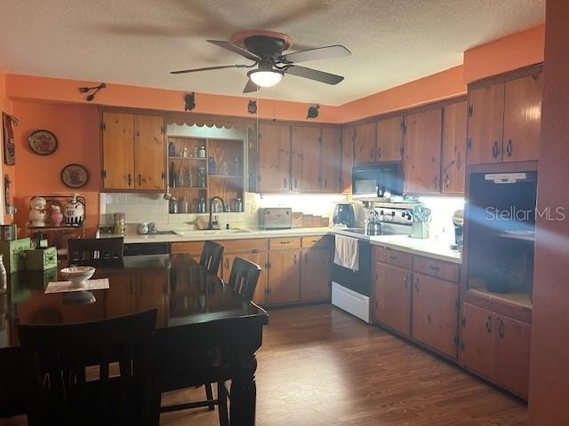 kitchen featuring a textured ceiling, dark hardwood / wood-style flooring, sink, white electric range oven, and ceiling fan