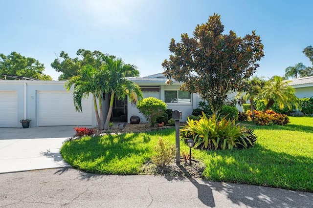 view of front of property featuring a front yard and a garage