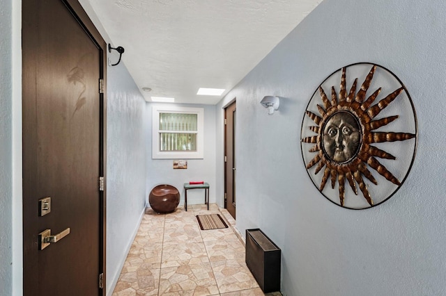 hall featuring a textured ceiling