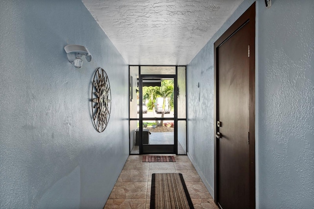 doorway to outside featuring a textured ceiling