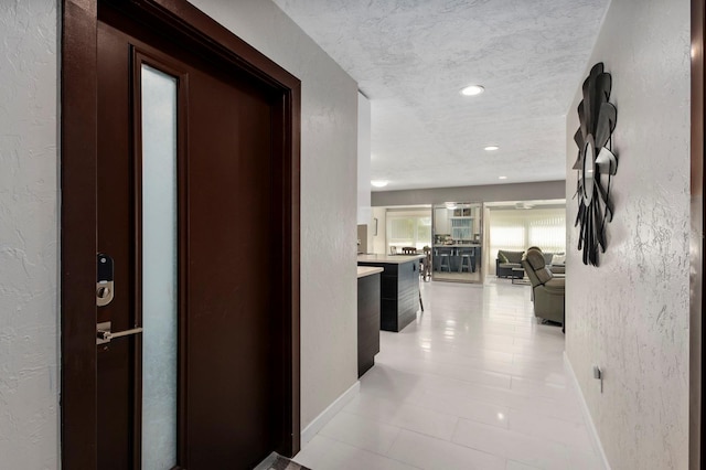 hall featuring a textured ceiling