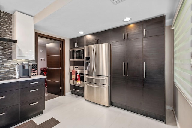 kitchen with appliances with stainless steel finishes, dark brown cabinets, and decorative backsplash