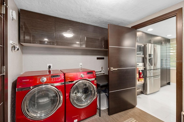 washroom with cabinets, washer and clothes dryer, and a textured ceiling