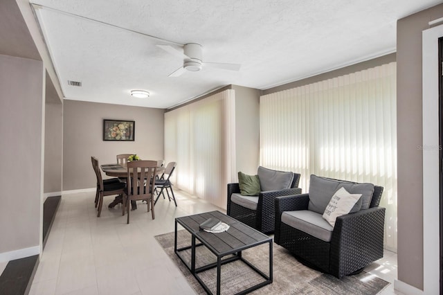 living room featuring a textured ceiling and ceiling fan