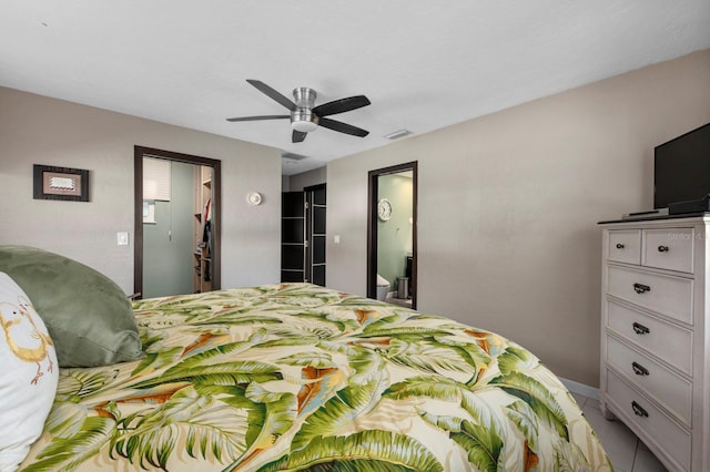 bedroom featuring light tile patterned floors, a spacious closet, ceiling fan, and a closet