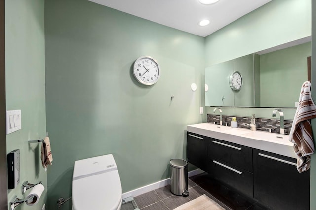 bathroom with vanity, toilet, and tasteful backsplash