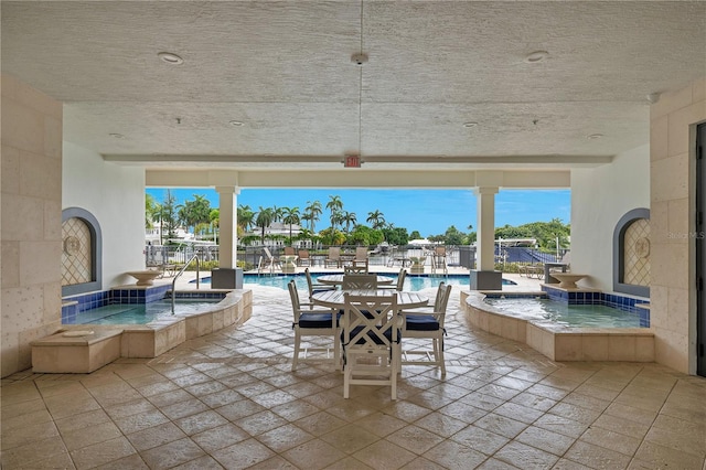 view of patio with a swimming pool with hot tub