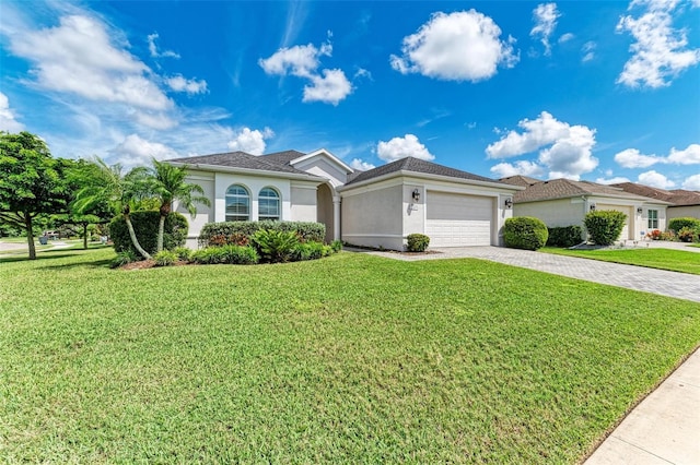 view of front of house with stucco siding, a garage, a front lawn, and decorative driveway