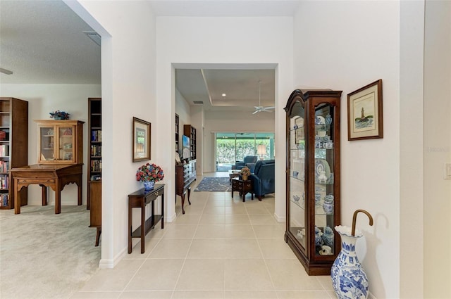 hall featuring a textured ceiling and light carpet