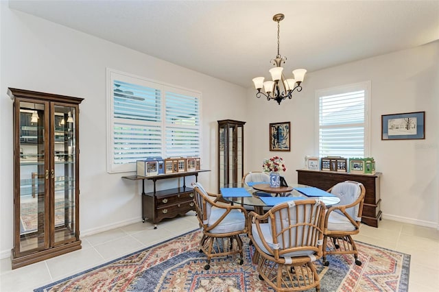 dining area with baseboards, light tile patterned floors, and an inviting chandelier