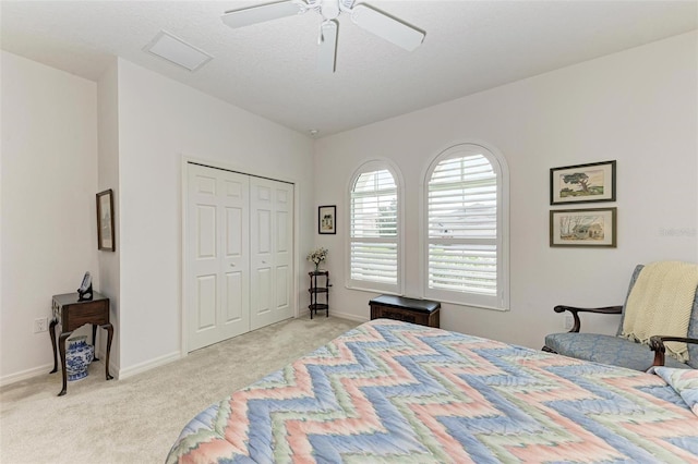 bedroom featuring a closet, light carpet, baseboards, and ceiling fan