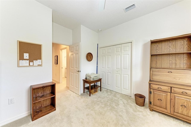 interior space with a textured ceiling and light colored carpet