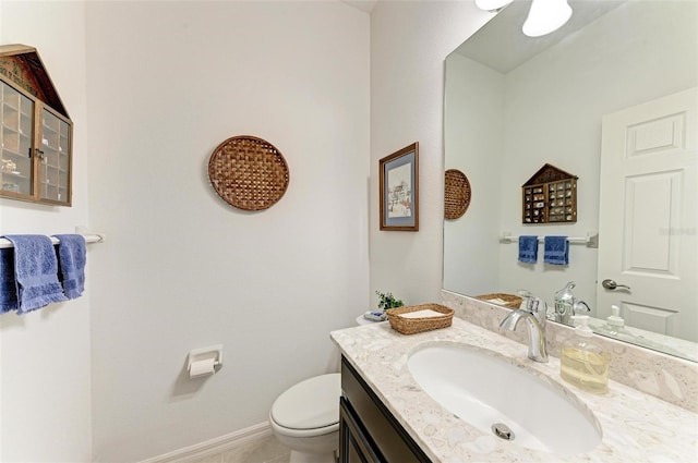 half bathroom with toilet, vanity, and baseboards
