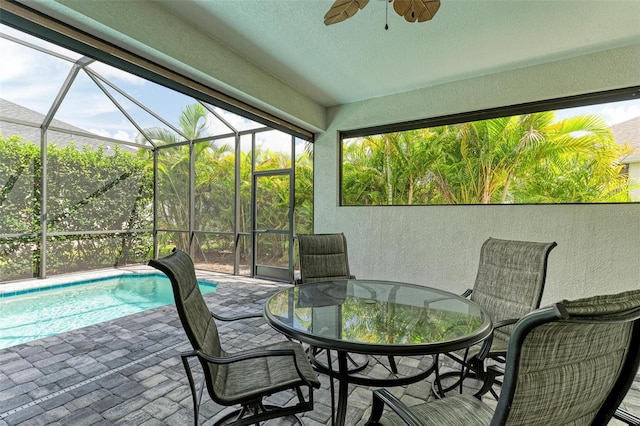 sunroom / solarium with ceiling fan and a pool