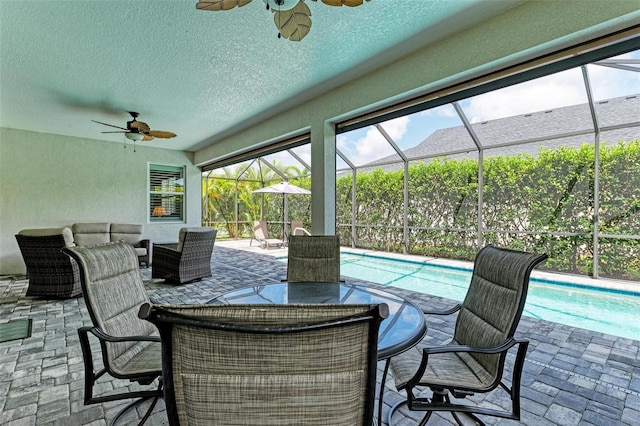 view of patio / terrace with an outdoor pool, an outdoor hangout area, outdoor dining space, glass enclosure, and a ceiling fan