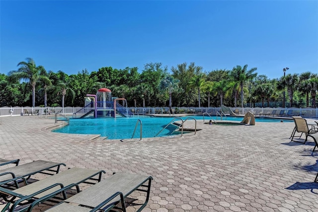 community pool with fence and a patio