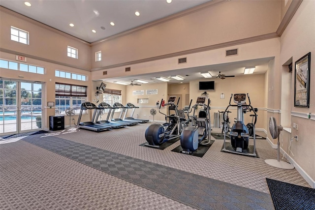 workout area with crown molding, a high ceiling, ceiling fan, and carpet flooring